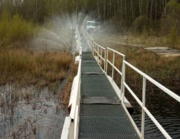 Pontonbrücke neben der Stahlrohrleitung. Durch die Beschädigung tritt Wasser aus wie bei einem Rasensprenger.