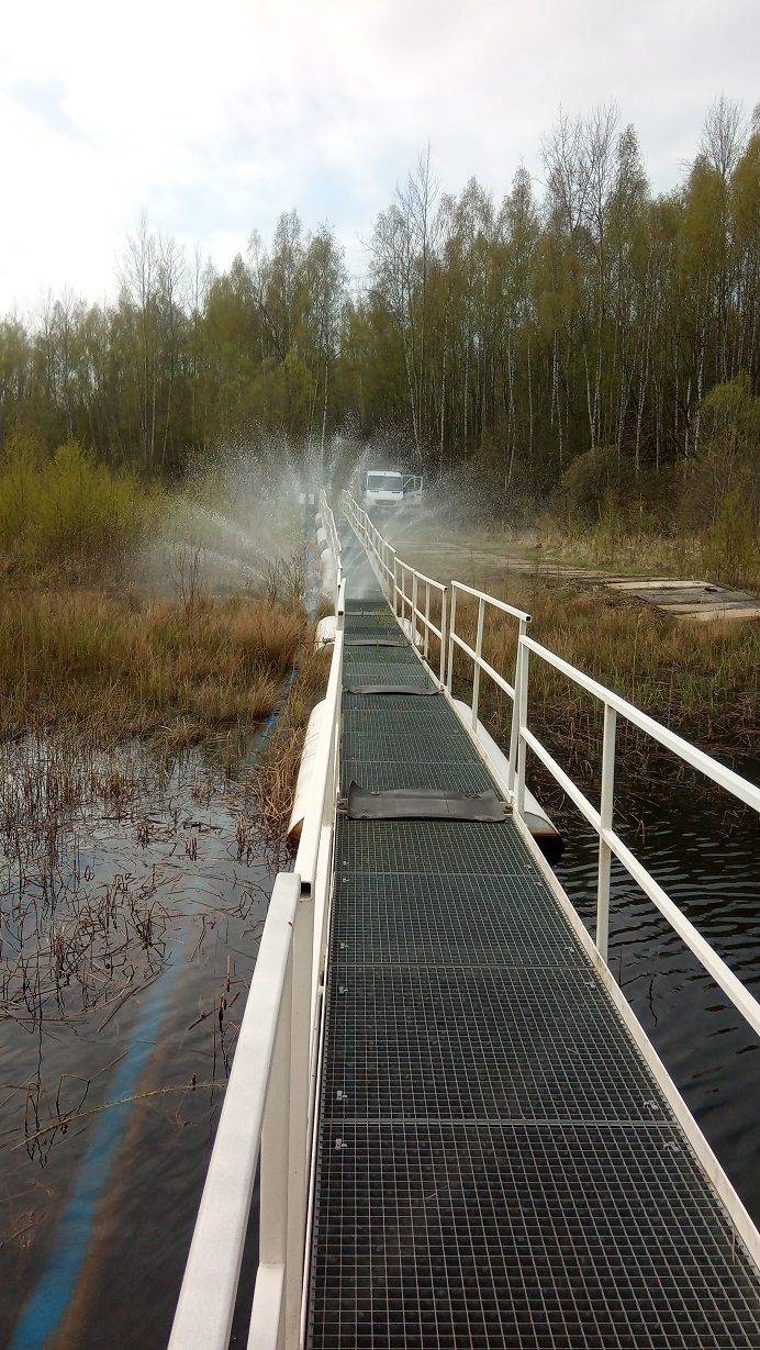 Pontonbrücke neben der Stahlrohrleitung. Durch die Beschädigung tritt Wasser aus wie bei einem Rasensprenger.
