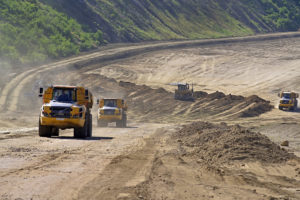 Baufahrzeuge beim Pendeln mit den Erdmassen